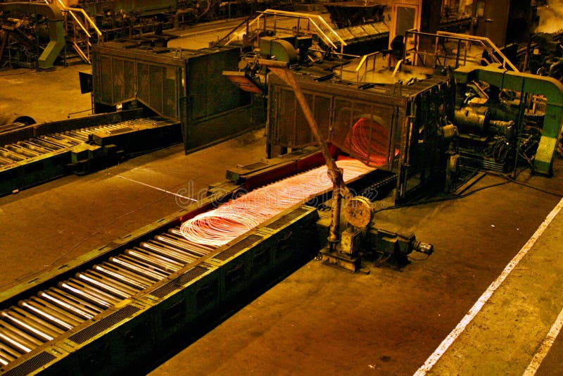 Rolling hot steel bars in steelworks finishing mill. Products are construction shapes, railway line and wire rod royalty free stock photo Rolling hot steel bars in steelworks finishing mill. Products are construction shapes, railway line and wire rod royalty free stock photo