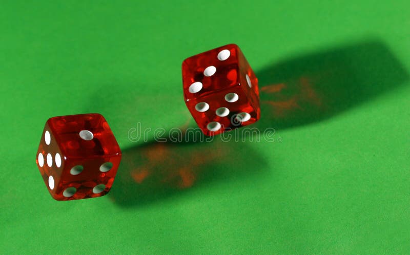 Rolling red dice on green table