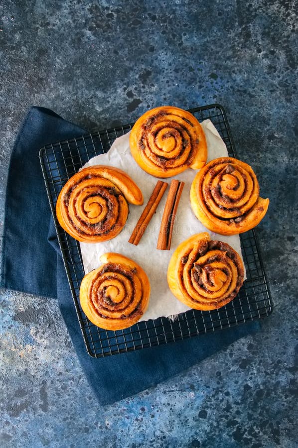 Rollos de canela clásicos - cinnabons en un estante de rejilla Vagos de la piedra azul fotografía de archivo libre de regalías Rollos de canela clásicos - cinnabons en un estante de rejilla Vagos de la piedra azul fotografía de archivo libre de regalías