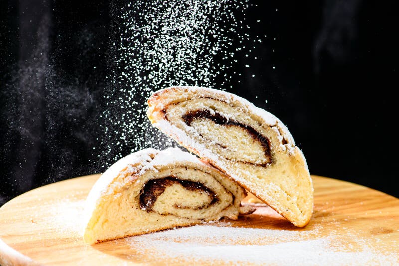 Rollos de canela recientemente cocidos asperjados con el azúcar en polvo en el wo imagen de archivo Rollos de canela recientemente cocidos asperjados con el azúcar en polvo en el wo imagen de archivo