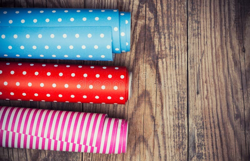 Rolls of colored wrapping paper on wooden background. Rolls of colored wrapping paper on wooden background