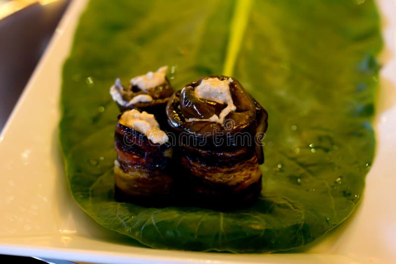 Rolls der Aubergine mit einer Füllung von Walnüssen, ausgebreitet auf einem Blatt lizenzfreie stockbilder Rolls der Aubergine mit einer Füllung von Walnüssen, ausgebreitet auf einem Blatt lizenzfreie stockbilder