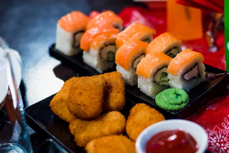 Rolls with Fish on a Plate with Sauce and Chicken Nuggets Stock Photo
