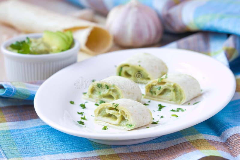 Rolls wickelte Brot, Tortilla, das Pittabrot ein, das mit Avocadocreme angefüllt wurde stockbild Rolls wickelte Brot, Tortilla, das Pittabrot ein, das mit Avocadocreme angefüllt wurde stockbild