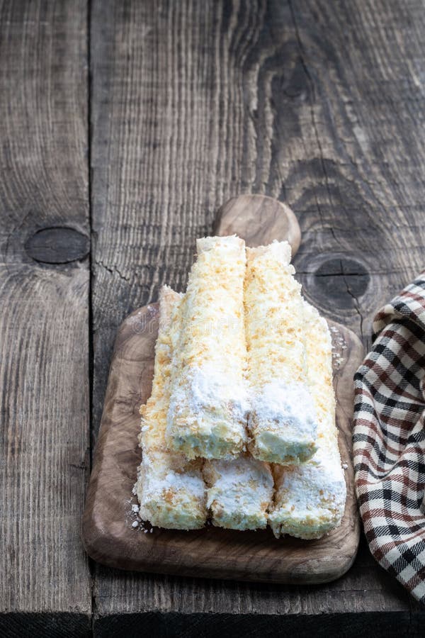 Rolos açucarados com nata em mesa de madeira fotos de stock royalty free