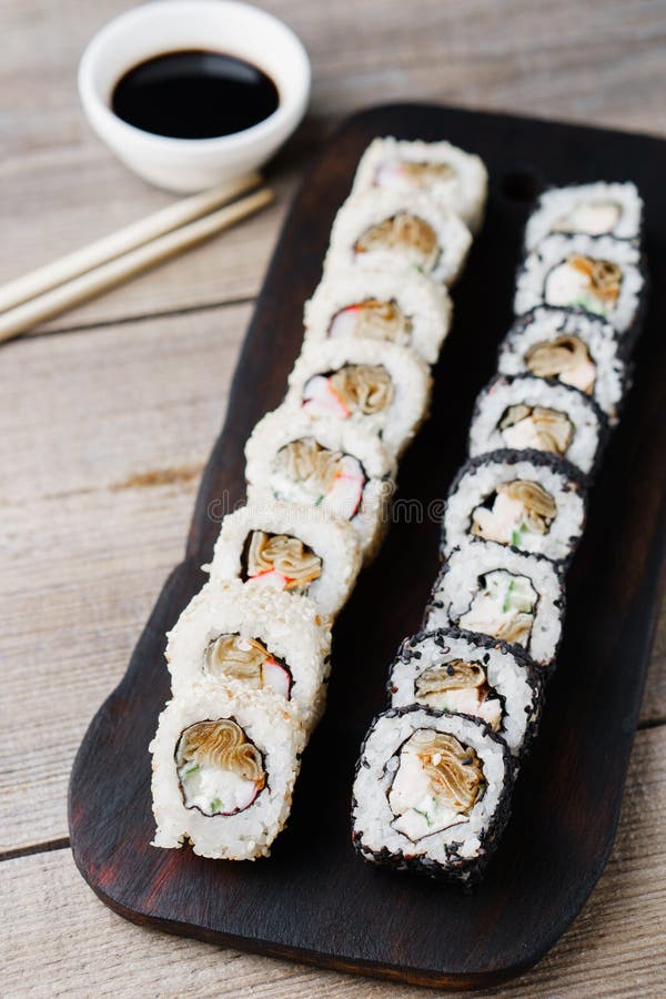 Rolos de sushi japoneses com molho e hashis fotografia de stock Rolos de sushi japoneses com molho e hashis fotografia de stock