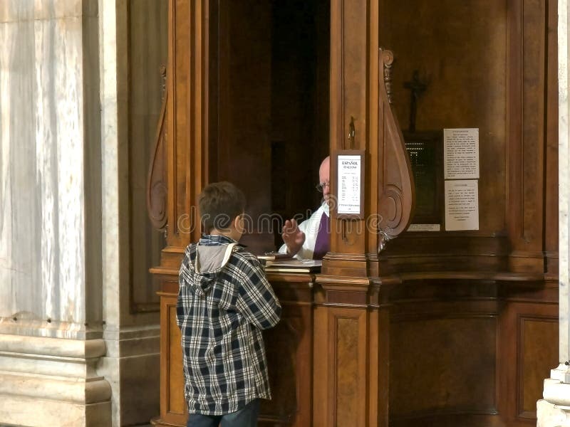 ROME, ITALY- SEPTEMBER 30, 2015: a boy performing catholic confession at the basilica santa maria maggiore in rome, italy. ROME, ITALY- SEPTEMBER 30, 2015: a boy performing catholic confession at the basilica santa maria maggiore in rome, italy