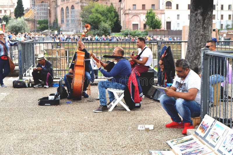 Roma, Itália - 7 de outubro de 2018: Os músicos da rua estão felizes manter distraído turistas na parte histórica da cidade perto imagem de stock royalty free Roma, Itália - 7 de outubro de 2018: Os músicos da rua estão felizes manter distraído turistas na parte histórica da cidade perto imagem de stock royalty free
