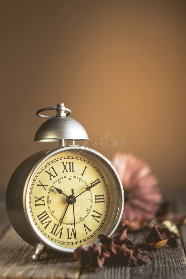 Roman Numeral no despertador do vintage e na pilha de fundo do livro fotografia de stock Roman Numeral no despertador do vintage e na pilha de fundo do livro fotografia de stock