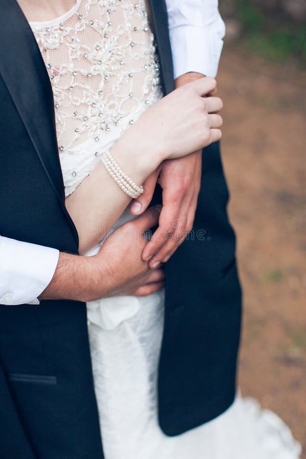 Romance: El novio abraza a la novia en un vestido blanco fotos de archivo libres de regalías Romance: El novio abraza a la novia en un vestido blanco fotos de archivo libres de regalías