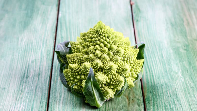 Romanesco crudo orgánico verde sano de la col Manojo de bróculi verde fresco en un tablero de madera Visión superior, lugar para foto de archivo libre de regalías Romanesco crudo orgánico verde sano de la col Manojo de bróculi verde fresco en un tablero de madera Visión superior, lugar para foto de archivo libre de regalías