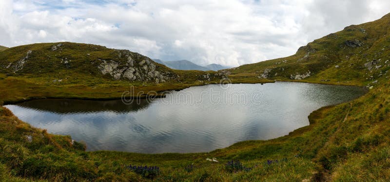 Romanian Carpathians and glacial lake Capra. Landscape with Fagaras mountain range and Capra glacial lake in Romania royalty free stock photo Romanian Carpathians and glacial lake Capra. Landscape with Fagaras mountain range and Capra glacial lake in Romania royalty free stock photo