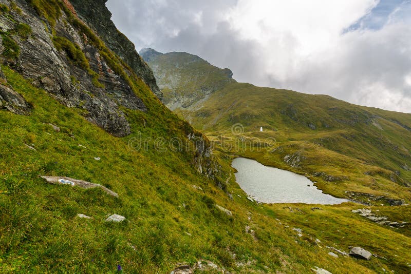 Romanian Carpathians and glacial lake Capra. Landscape with Fagaras mountain range and Capra glacial lake in Romania stock photo Romanian Carpathians and glacial lake Capra. Landscape with Fagaras mountain range and Capra glacial lake in Romania stock photo