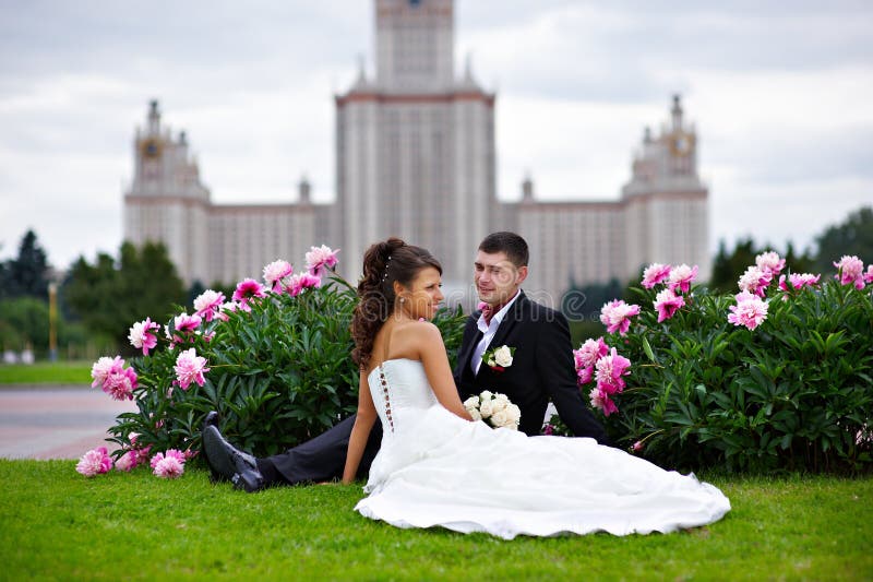 Romantic bride and groom in park of peony flowers