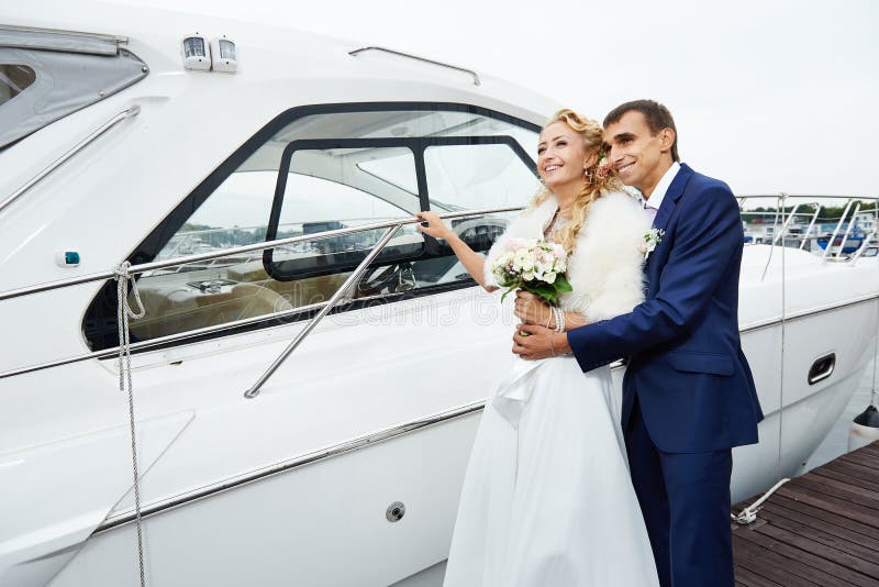 Romantic bride and groom on the pier with yacht