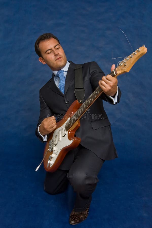 Romantic businessman with guitar over blue