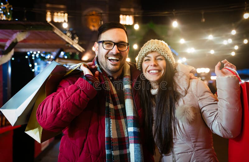 Romantic Christmas shopping. Happy young couple buying gifts for family. Sale and people concept. stock photos