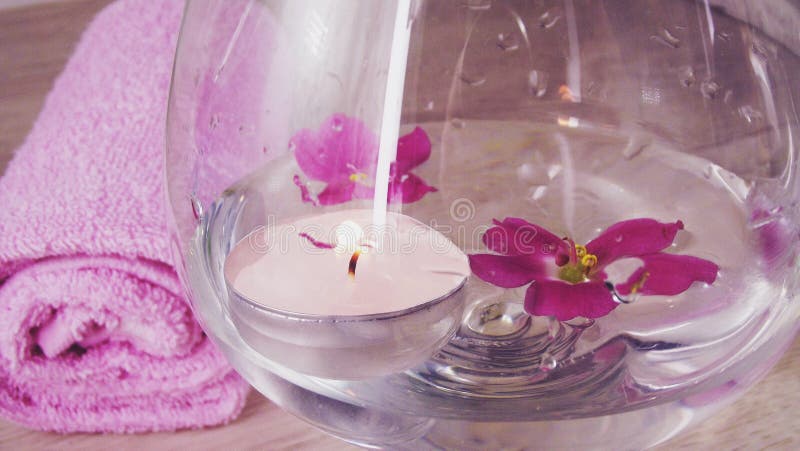 Romantic composition with a candle and violet flowers floating in a bowl of water. royalty free stock photo Romantic composition with a candle and violet flowers floating in a bowl of water. royalty free stock photo