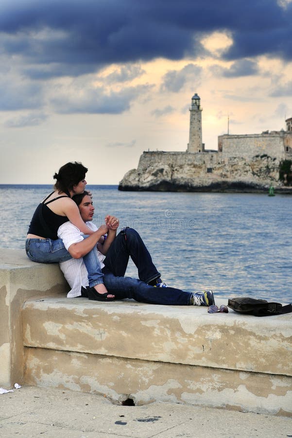 Portrait of young romantic couple relaxing on the havana malecon. Portrait of young romantic couple relaxing on the havana malecon.