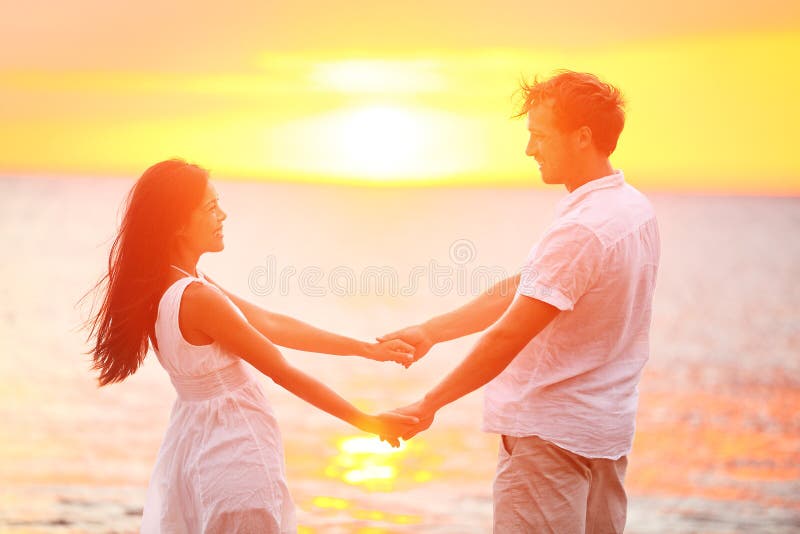 Romantic couple lovers holding hands, beach sunset.