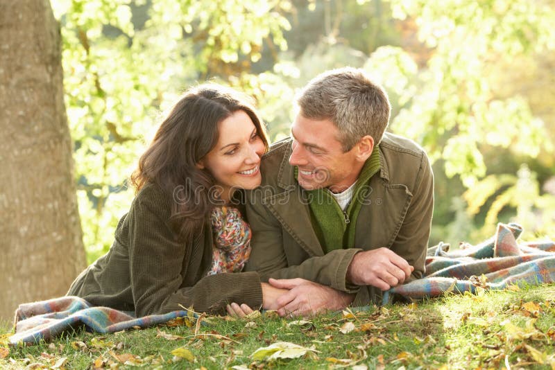 Romantic Couple Relaxing Outdoors In Autumn Landscape. Happy embracing couple stock images, royalty-free photos and pictures