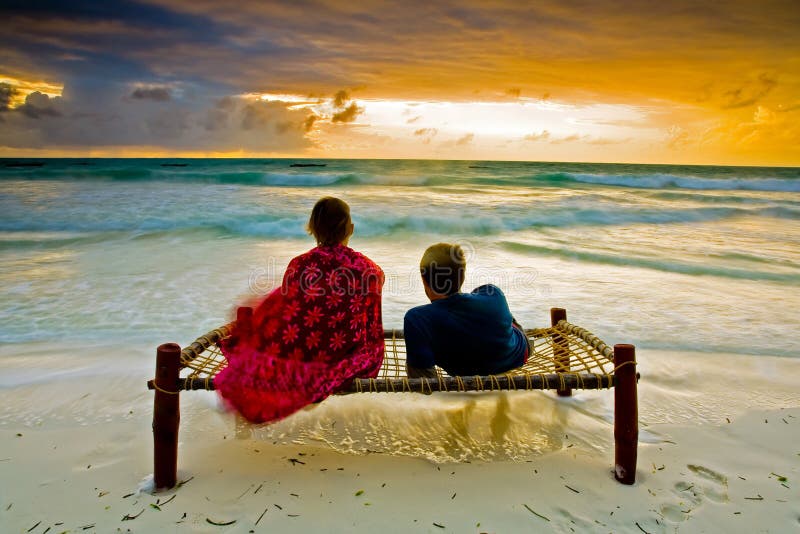 A romantic couple on honeymoon enjoying a breathtaking scene on a tropical beach in Zanzibar, Africa. A romantic couple on honeymoon enjoying a breathtaking scene on a tropical beach in Zanzibar, Africa