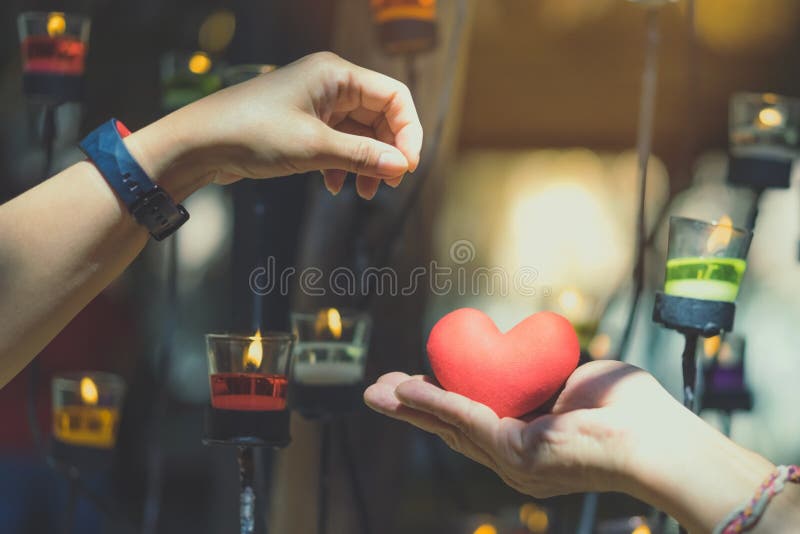 Romantic couple on valentines day. Happy joyful woman giving man heart shape little pillow in a candle light.In the afternoon