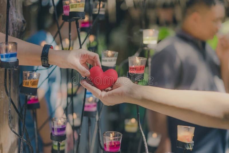 Romantic couple on valentines day. Happy joyful woman giving man heart shape little pillow in a candle light.In the afternoon