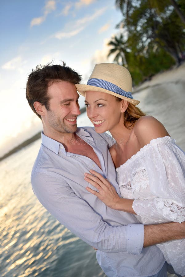 Romantic Couple Walking On The Tropical Beach In Sunset Stock Photo