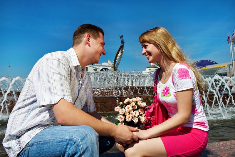 Romantic dating young guy and girl in city square