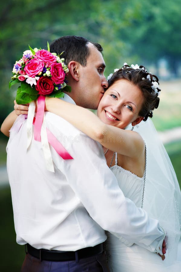 Romantic kiss happy bride and groom