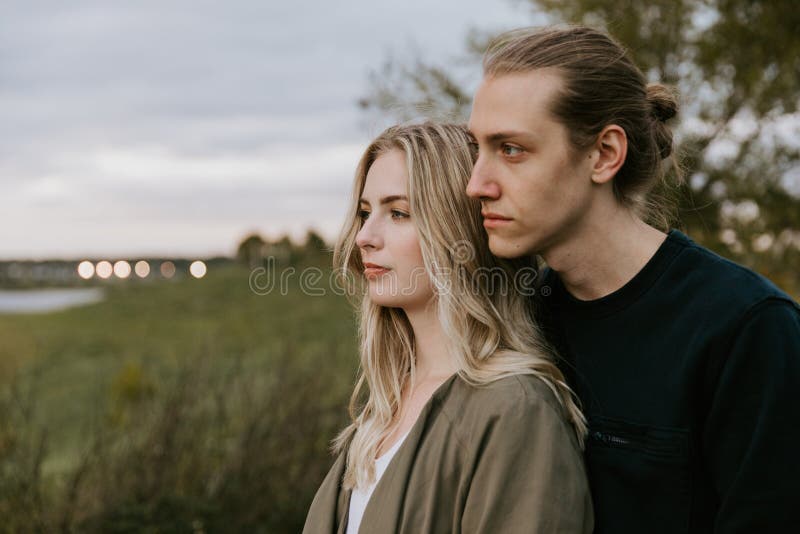 Romantic and Loving Young Adult Couple at the Park Looking At Nature and the Horizon for Portrait Pictures stock images Romantic and Loving Young Adult Couple at the Park Looking At Nature and the Horizon for Portrait Pictures stock images