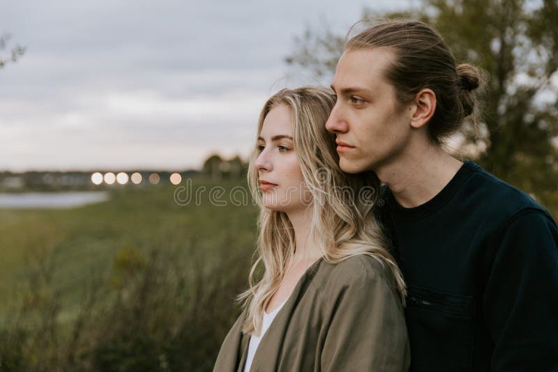 Romantic and Loving Young Adult Couple at the Park Looking At Nature and the Horizon for Portrait Pictures stock images Romantic and Loving Young Adult Couple at the Park Looking At Nature and the Horizon for Portrait Pictures stock images