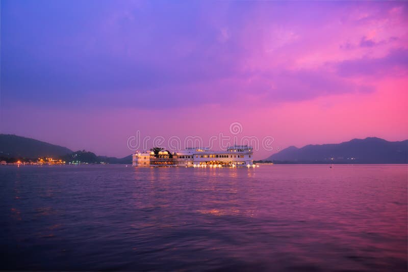 Romantic luxury India travel tourism - Lake Palace Jag Niwas complex on Lake Pichola on sunset in twilight with dramatic sky, Udaipur, Rajasthan, India. Romantic luxury India travel tourism - Lake Palace Jag Niwas complex on Lake Pichola on sunset in twilight with dramatic sky, Udaipur, Rajasthan, India