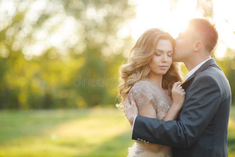 Romantic moments of a young wedding couple on summer meadow