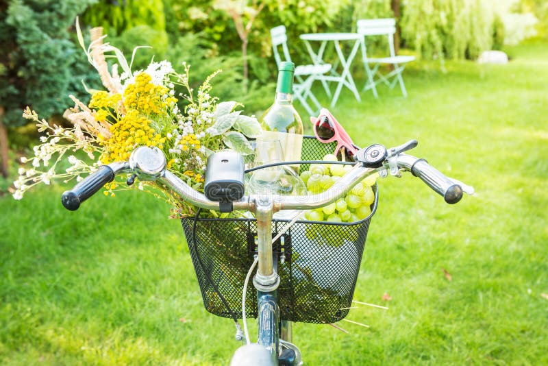 Romantic picnic - flowers and wine in bicycle basket