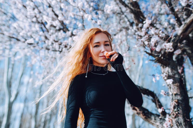 Romantic portrait of woman smelling flower stock photography