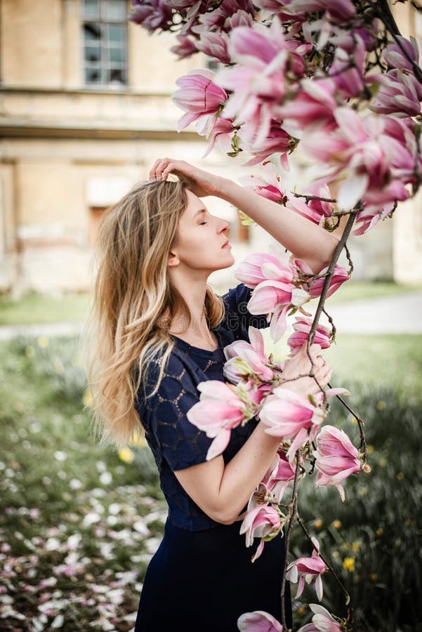 Romantic portrait of young blonde woman posing with magnolia tree in full bloom stock photos Romantic portrait of young blonde woman posing with magnolia tree in full bloom stock photos
