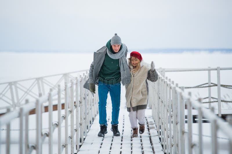 Romantic rendezvous of two lovers on valentine`s day on a pier on a frozen river