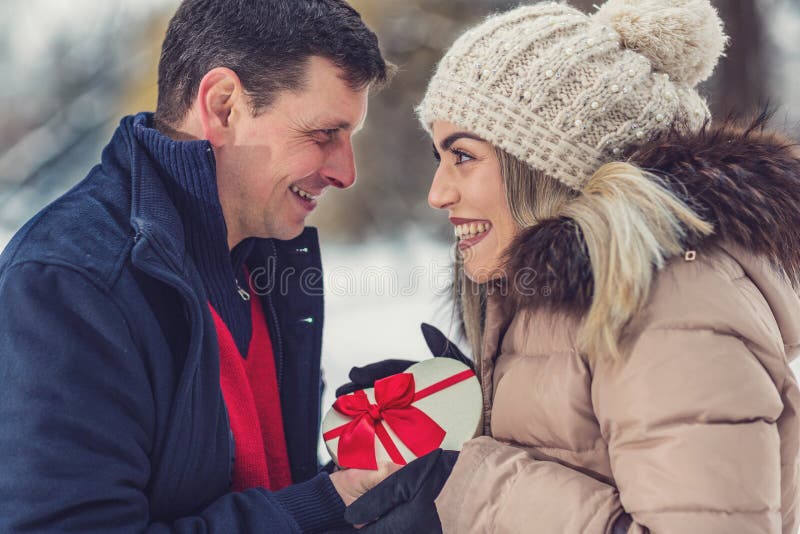 Romantic surprise for Christmas, guy gives a gift to a girl stock photos Romantic surprise for Christmas, guy gives a gift to a girl stock photos