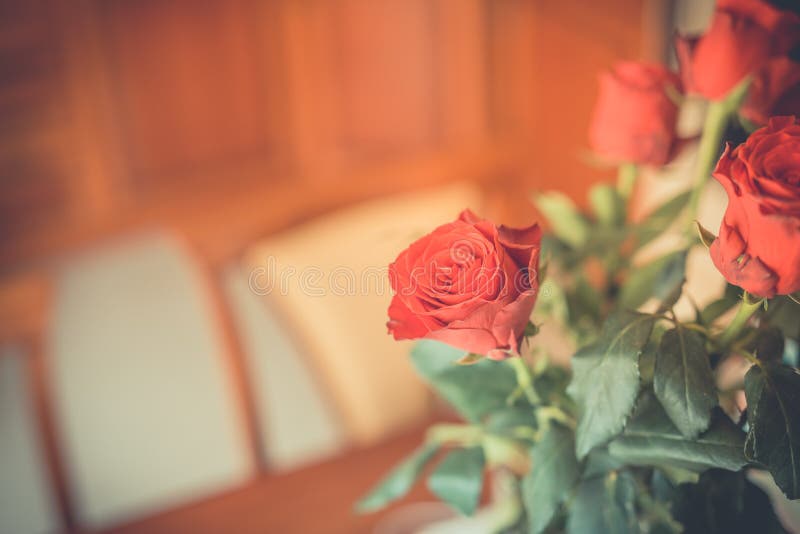 Red roses on table top in vintage style and colors