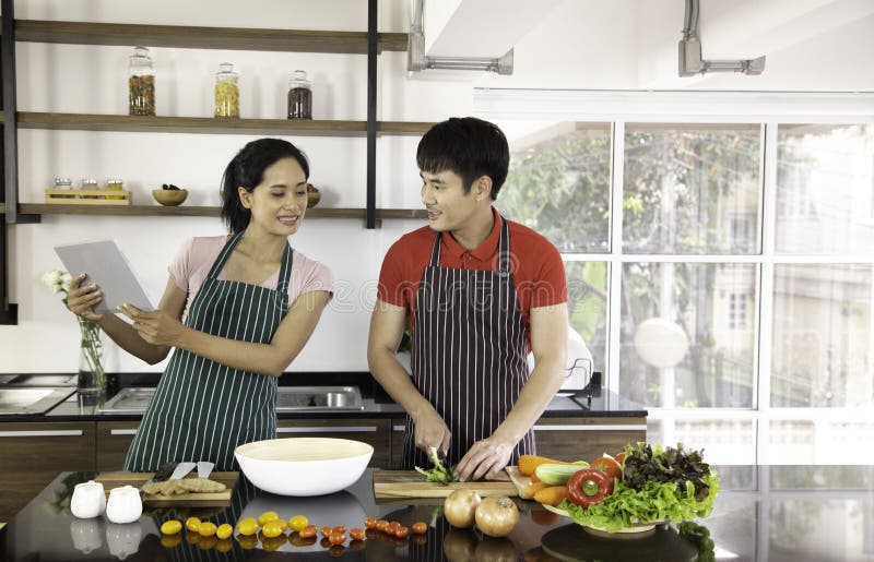 Romantic young lovely couple cooking food in the kitchen stock photography Romantic young lovely couple cooking food in the kitchen stock photography