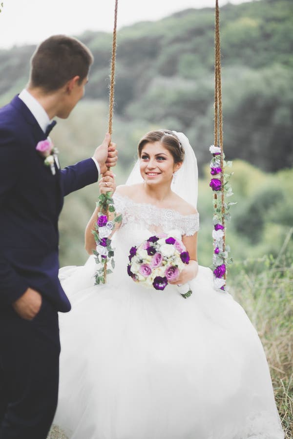 Romantisch, Märchen, glückliche Jungvermähltenpaare, die in einem Park, Bäume im Hintergrund umarmen und küssen stockfotos Romantisch, Märchen, glückliche Jungvermähltenpaare, die in einem Park, Bäume im Hintergrund umarmen und küssen stockfotos