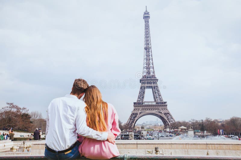 Romantisch paar die de toren van Eiffel in Parijs bekijken stock foto Romantisch paar die de toren van Eiffel in Parijs bekijken stock foto