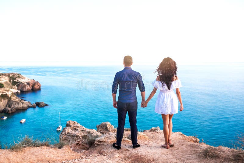 Romantisch paar op de rots dichtbij mooi overzees strand royalty-vrije stock fotografie Romantisch paar op de rots dichtbij mooi overzees strand royalty-vrije stock fotografie