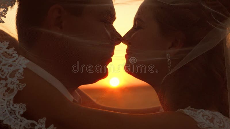 Romantisch stel, graag zoend op zonsondergang Het concept van een gelukkig gezin bruidekus en groomkus bij zonsondergang sluiten