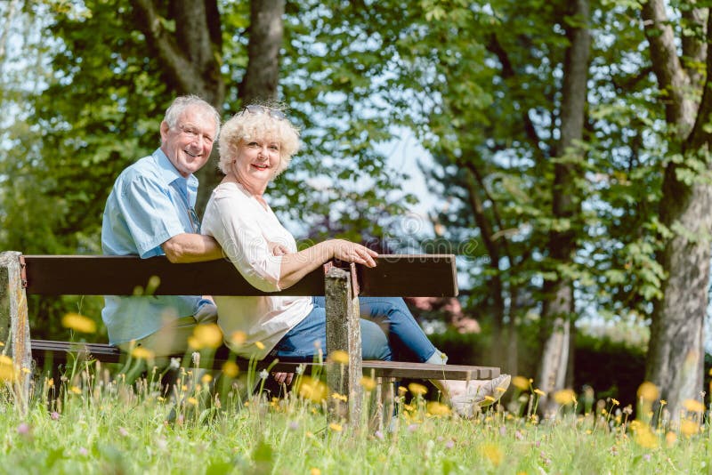 Romantische bejaarde paarzitting samen op een bank in een rustige dag stock foto Romantische bejaarde paarzitting samen op een bank in een rustige dag stock foto