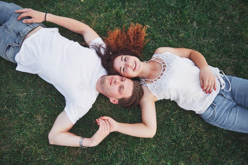 Romantische Paare von den jungen Leuten, die auf Gras im Park liegen Sie schauen glücklich Ansicht von oben stockfoto Romantische Paare von den jungen Leuten, die auf Gras im Park liegen Sie schauen glücklich Ansicht von oben stockfoto