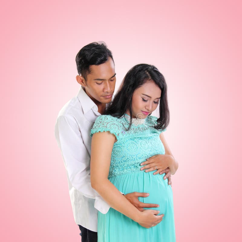 Romantische schwangere Frau und ihre Ehemannumfassung