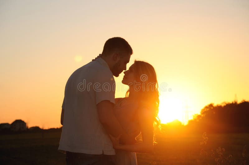 Romantische sinnliche junge Paare in der Liebe, die auf dem Gebiet an der Sonne aufwirft stockbild Romantische sinnliche junge Paare in der Liebe, die auf dem Gebiet an der Sonne aufwirft stockbild